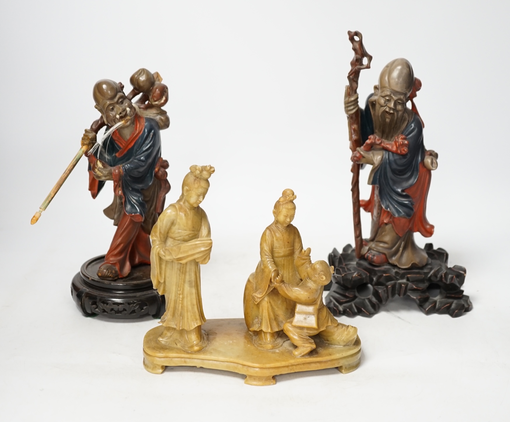 Two Chinese Fuzhou lacquer figures of Shou Lao and a smaller soapstone figure group, tallest Fuzhou figure 25cm high (3). Condition - some wear but fair